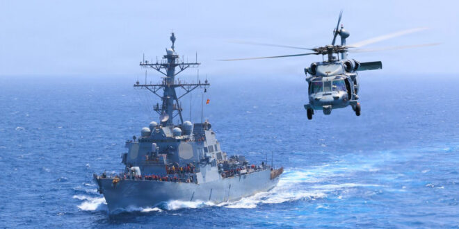 USS Donald Cook (DDG 75) transits the Arabian Sea while an MH-60S Sea Hawk flies nearby.