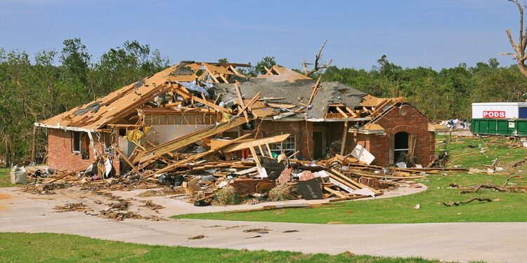 FEMA_-_44359_-_Oklahoma_tornado_destroyed_home - Poli Alert Collapsed brick house with extensive roof and wall damage, debris scattered across lawn after a storm/tornado