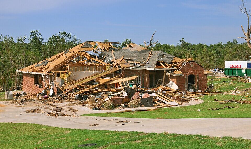 FEMA_-_44359_-_Oklahoma_tornado_destroyed_home - Poli Alert Collapsed brick house with extensive roof and wall damage, debris scattered across lawn after a storm/tornado